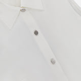 Close-up of the Airflex Leah Ruched Side Tank Top by RAG & BONE, featuring a white sleeveless design with subtle side ruching and the rag & bone brand label inside the neckline.