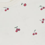 A close-up of the RAG & BONE All Over Cherry T-shirt in white Peruvian cotton, featuring a playful cherry print with small red cherries throughout and a visible collar label.