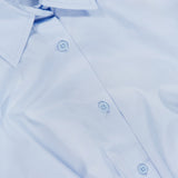A close-up of the RAG & BONE Andy Pleated Drawcord Top in light blue, featuring a pointed collar and visible buttons, lying flat. The shirt tag displays the brand name.