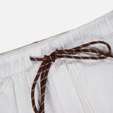 Close-up of the Atlas Drawcord Linen Pant by RAG & BONE featuring a high-rise drawstring waist tied in a bow, white linen fabric, and light brown stitching, set against a plain white background.