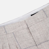 Close-up of the RAG & BONE Chappell Plaid Linen Pant in light beige with gray stripes, featuring pleats and a defined waistband—ideal for sophisticated styling—set against a white background.