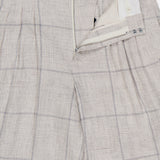 The RAG & BONE Chappell Plaid Linen Pant features a light beige plaid pattern, high-rise fit, zipper fly with button closure, and a partially open waistband that shows the inner lining and label.