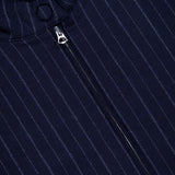 Close-up of the Eliza Striped Bomber Jacket by RAG & BONE, featuring navy blue pinstripe fabric, a vertical silver zipper, and two fabric-covered buttons near the collar.