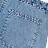 A close-up of RAG & BONE's Featherweight Logan Track Pant in Eversport shows light blue featherweight denim with an elastic waistband, a single back pocket featuring visible stitching, and a small white embroidered logo near the top right corner.