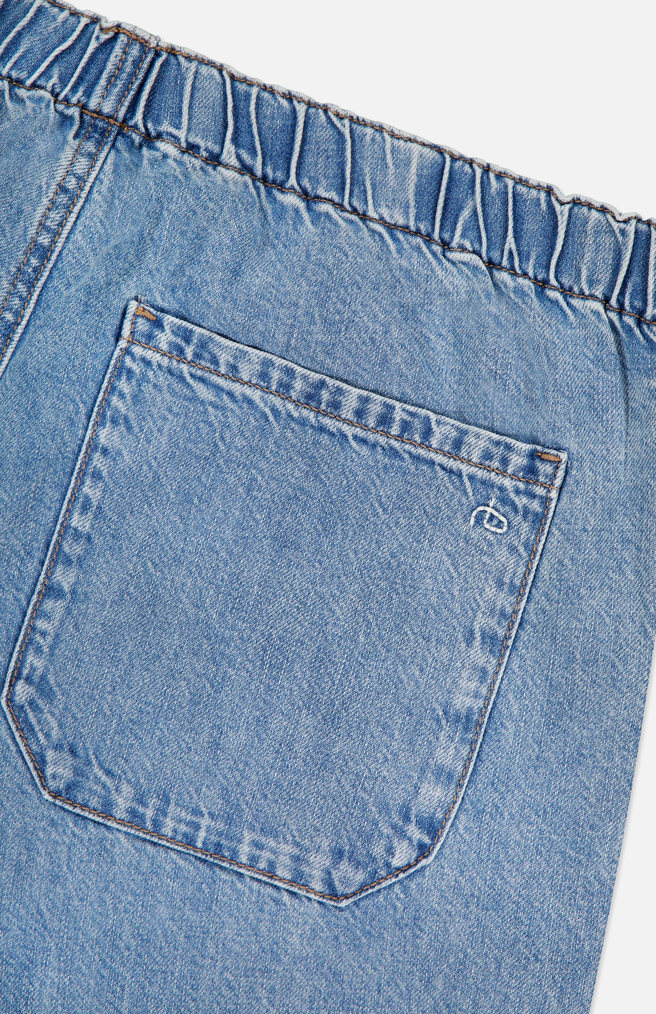 A close-up of RAG & BONE's Featherweight Logan Track Pant in Eversport shows light blue featherweight denim with an elastic waistband, a single back pocket featuring visible stitching, and a small white embroidered logo near the top right corner.