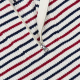 Close-up of the Georgie Stripe Half Zip Sweater by RAG & BONE—an ivory zip neck sweater with red, navy, and white stripes, ribbed texture, a crisp white collar, and partially unzipped silver zipper.