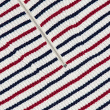 Close-up of the Georgie Stripe Half Zip Sweater by RAG & BONE, showcasing ribbed fabric with horizontal red, navy blue, and white stripes and a white zip neck running diagonally across the upper left.