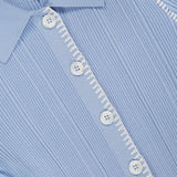 Close-up of the Harper Short Sleeve Cardigan Sweater by RAG & BONE in light blue, featuring a ribbed knit texture, white buttons, white decorative stitching on the placket, and a visible slim collar with the RAG & BONE tag.