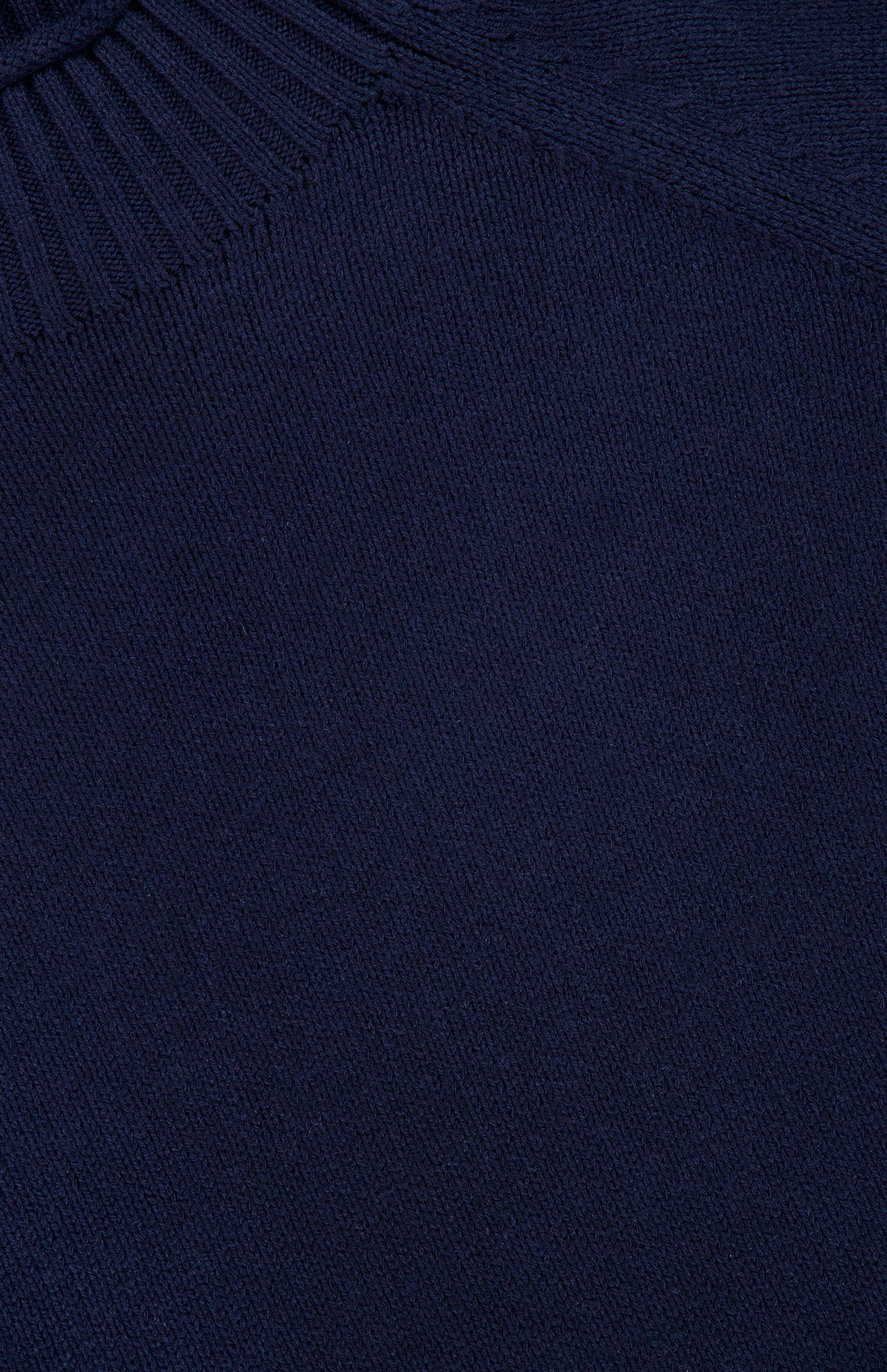 Close-up of a navy blue knit fabric from the RAG & BONE Hazel Roll Neck Sweater, highlighting the texture and stitching, with a ribbed collar edge visible at the top left corner.