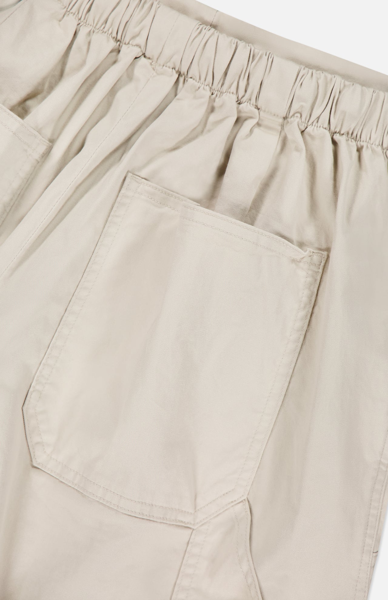 Close-up of the RAG & BONE Jolie Wide Leg Carpenter Pant in beige, featuring a wide-leg silhouette, elastic waistband, and a large front pocket with neat stitching.