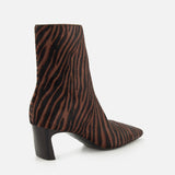 A side view of the Kai Zebra Ankle Boot by RAG & BONE in calf hair features brown and black zebra stripes, a pointed toe, and a chunky mid-height black heel, set against a plain white background.
