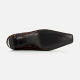 The image shows the bottom view of the Kai Zebra Ankle Boot by RAG & BONE, featuring a black sole and a brown and black zebra print upper.