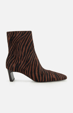 The Kai Zebra Ankle Boot by RAG & BONE features brown and black zebra-print calf hair, a pointed toe, and a low angled block heel, shown from the side on a white background.