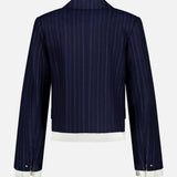 The Lawrence Striped Crop Blazer by RAG & BONE features navy pinstripes, white cuffs and hem, long sleeves, a notched collar, and modern womens suiting details. Shown from the back against a plain white background.