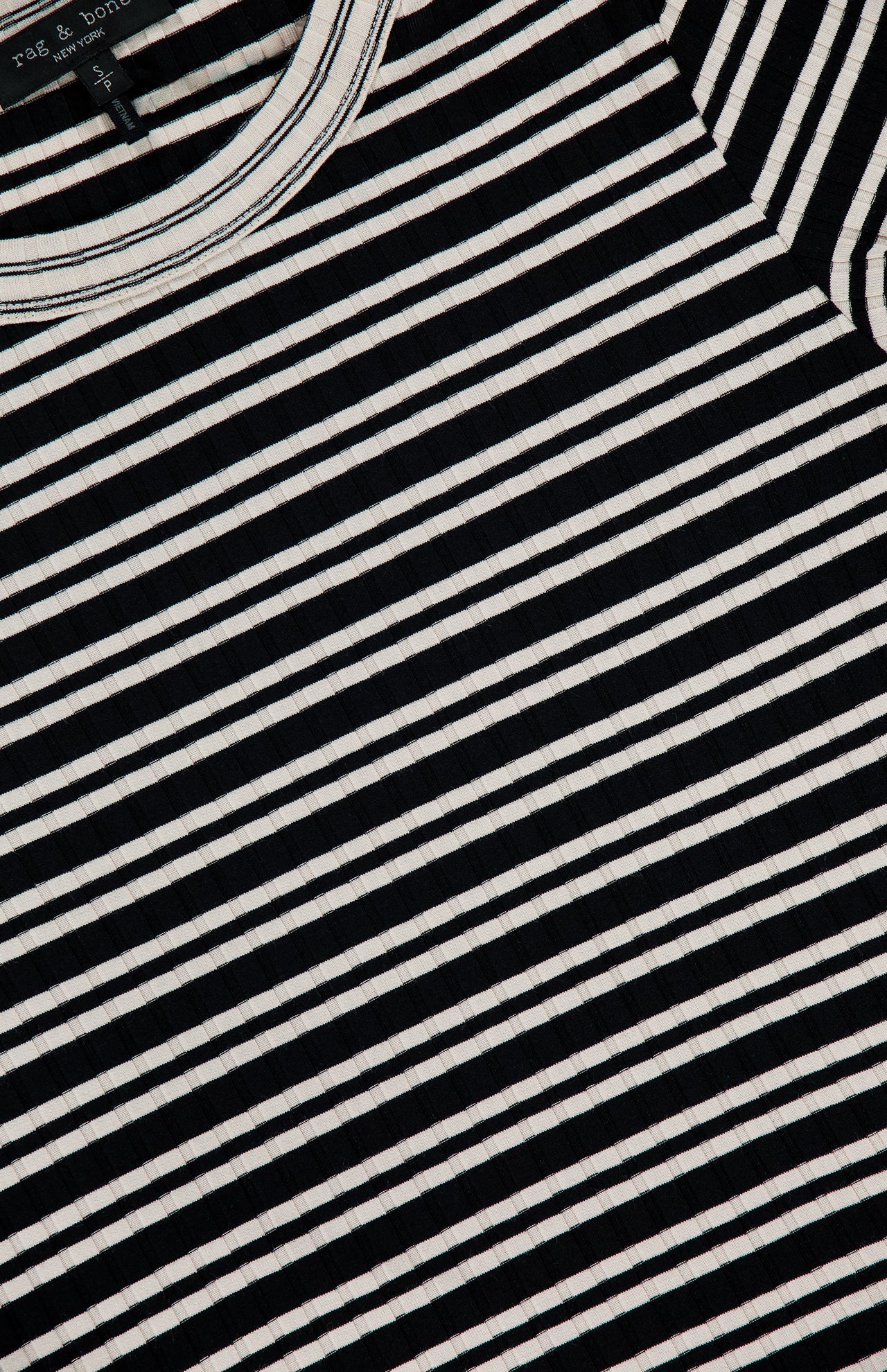 A close-up of the RAG & BONE Luca Stripe Contrast T-shirt shows its black and white horizontal stripes, part of the neckline with a visible tag, and highlights the silky-soft fabric.