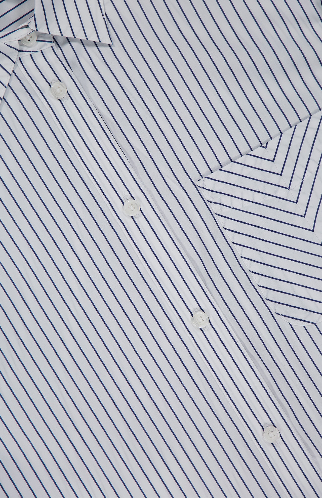 Close-up of the Lucia Stripe Mini Dress by RAG & BONE: a white cotton poplin shirtdress with thin blue stripes, white buttons, and a chest pocket. Diagonal stripes on the pocket and collar contrast with vertical stripes on the main fabric.
