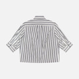 The Lucia Stripe Poplin Shirt by RAG & BONE is a loose, boxy-fit long-sleeve with black vertical stripes on white cotton poplin, buttoned cuffs, and a classic collar, shown from the back.