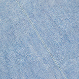 Close-up of light blue denim-like fabric with diagonal seam stitching and part of a rounded collar—details from the Miramar Kelly Jersey T-Shirt Dress by RAG & BONE.
