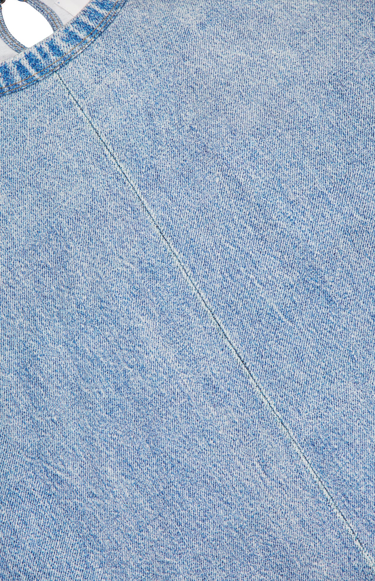 Close-up of light blue denim-like fabric with diagonal seam stitching and part of a rounded collar—details from the Miramar Kelly Jersey T-Shirt Dress by RAG & BONE.