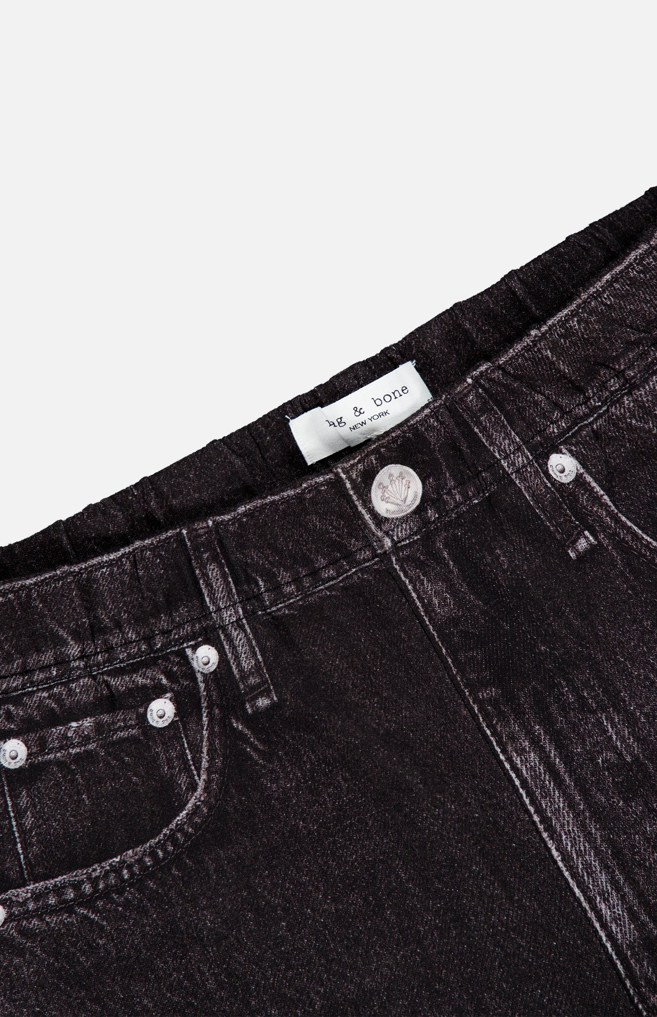 Close-up of the waistband and pockets of the Miramar Mallow Wide Leg Pull On Pant in Belmont by RAG & BONE, highlighting its black denim look, silver button detail, and signature sweatpant-jean style.