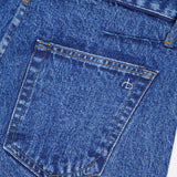 Close-up of the back pocket of RAG & BONE’s Miramar Slink Lounge Short in York, featuring blue denim, visible stitching, a small white embroidered logo, and a classic low-rise fit with a slightly textured look.