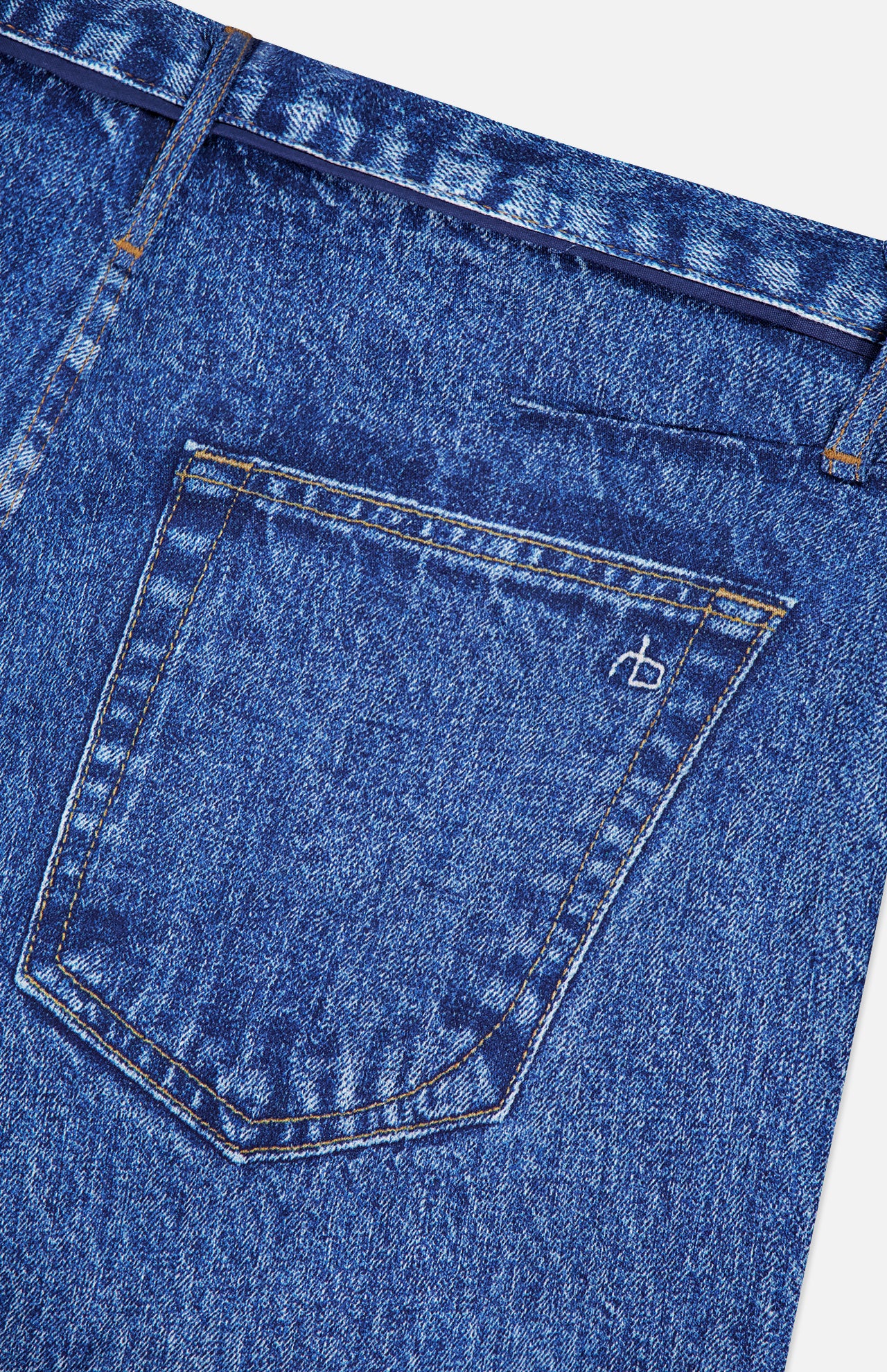 Close-up of the back pocket of RAG & BONE’s Miramar Slink Lounge Short in York, featuring blue denim, visible stitching, a small white embroidered logo, and a classic low-rise fit with a slightly textured look.
