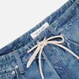 Close-up of the RAG & BONE Miramar Terry Drawstring Wide Leg Pant in Ellis, featuring a blue denim look, a white drawstring tied in a bow at the waist, and a visible rag & bone label sewn onto the inner waistband.