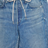 Close-up of the Miramar Terry Drawstring Wide Leg Pant in Ellis by RAG & BONE, featuring a blue denim-look finish with a white drawstring tie at the waist, silver rivets on the pockets, and a visible RAG & BONE label on the waistband. The wide leg silhouette adds a modern edge to this classic style.