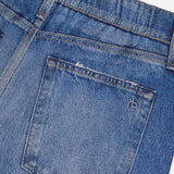 Close-up of the back pocket and waistband on the Miramar Terry Track Pull On Pant in Carst by RAG & BONE, showing faded blue detailing, an elastic waistband section, and a small stitched design on the pocket.