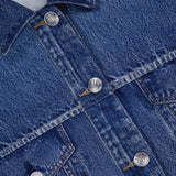 Close-up of the Miramar Terry Trucker Jacket by RAG & BONE, a blue denim-look jacket with flap pockets, silver buttons, visible stitching, and a rag & bone label inside the collar.