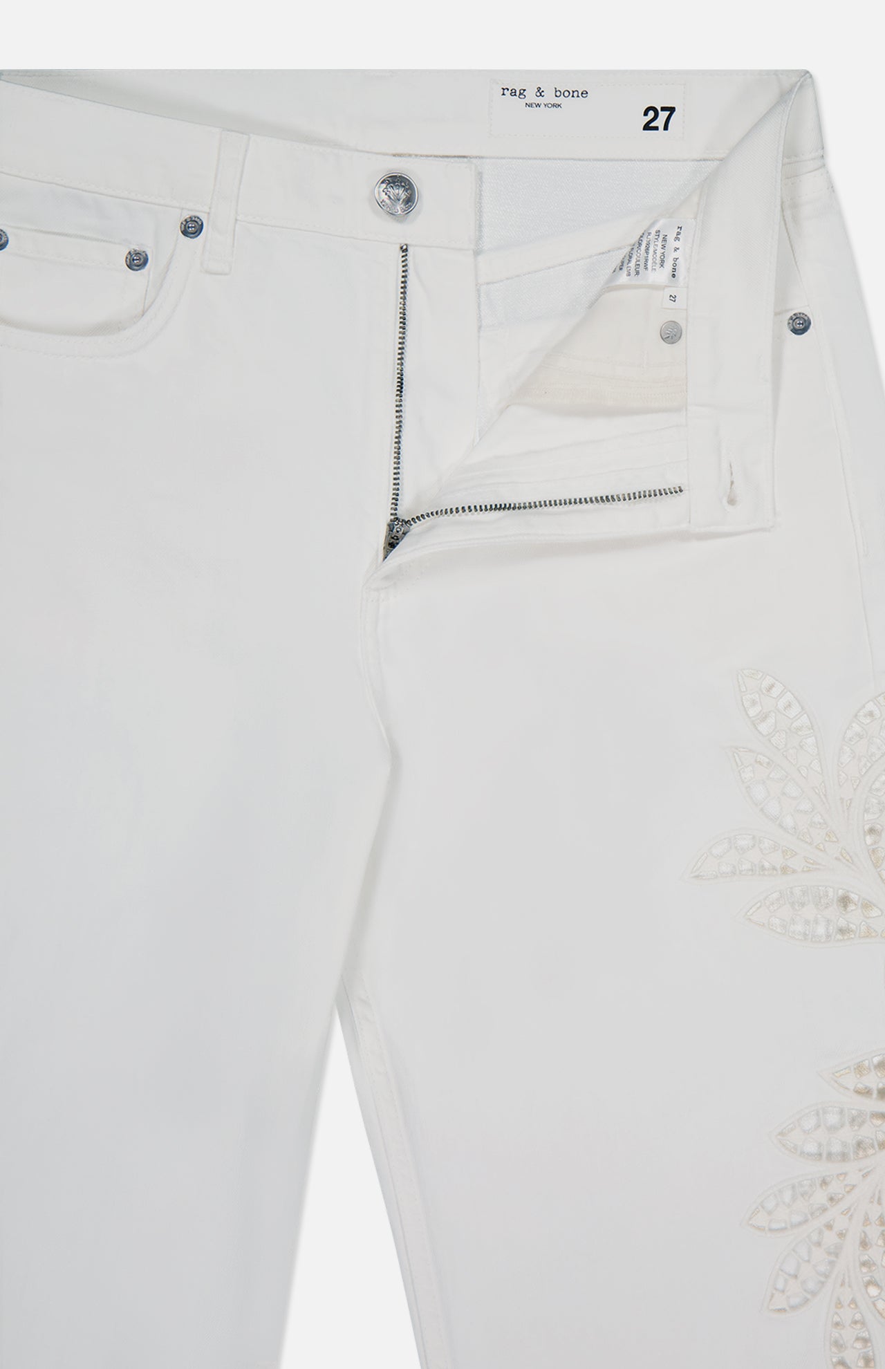 The Shea Full Straight Cut-out Pant by RAG & BONE features white straight legs, a partially open zipper and waistband, silver button, and an embroidered floral design on the right thigh. The label inside shows size 27.