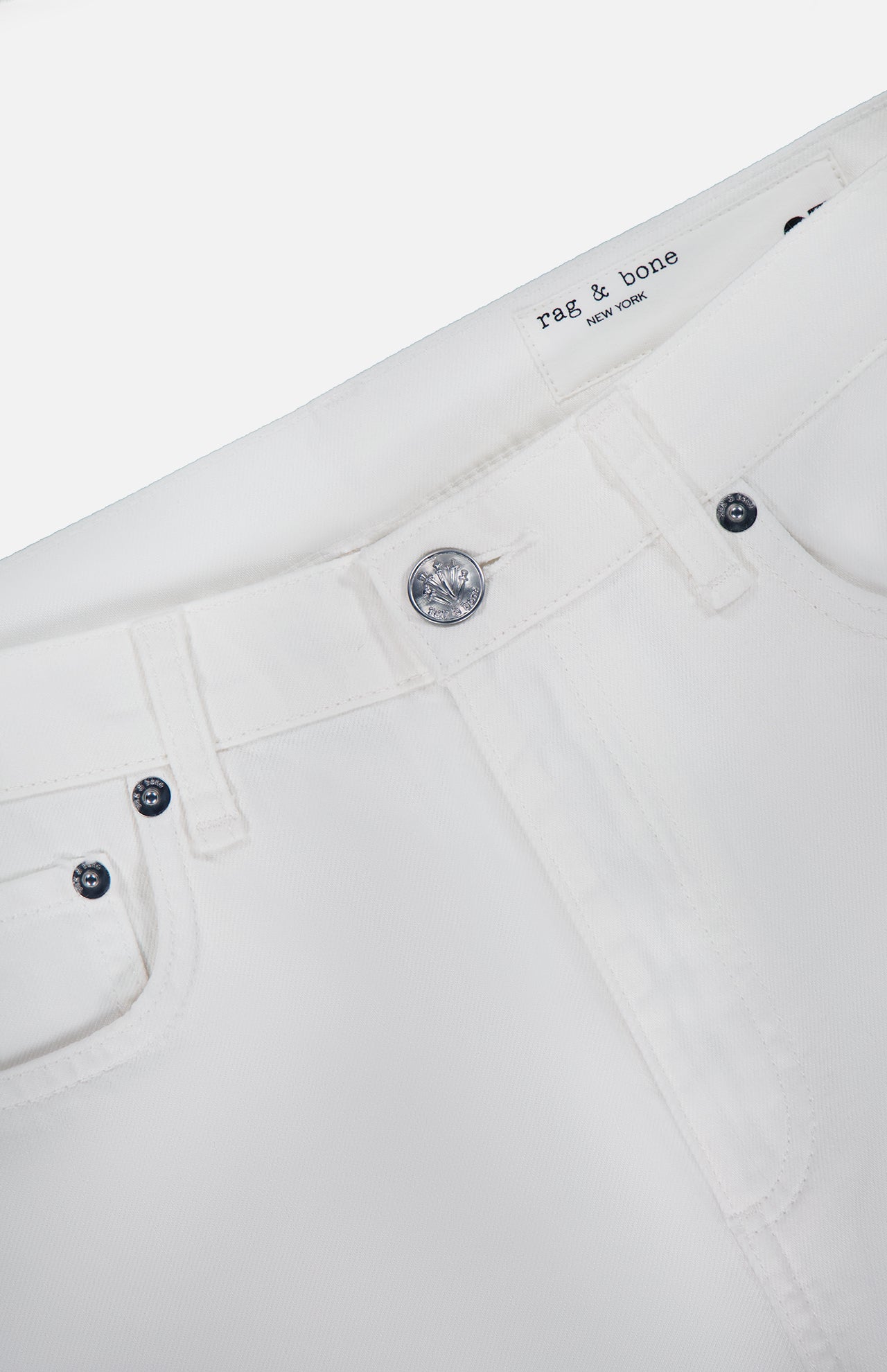 Close-up of the waistband and upper front of the Shea Full Straight Cut-out Pant by RAG & BONE, featuring belt loops, a metal button, visible stitching, and an interior RAG & BONE label.