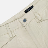 Close-up of the waist area of Stevie Utility Tapered Pant in light tan, 100% cotton, showing front button, belt loops, and front pockets. Inside the waistband is a black RAG & BONE label.