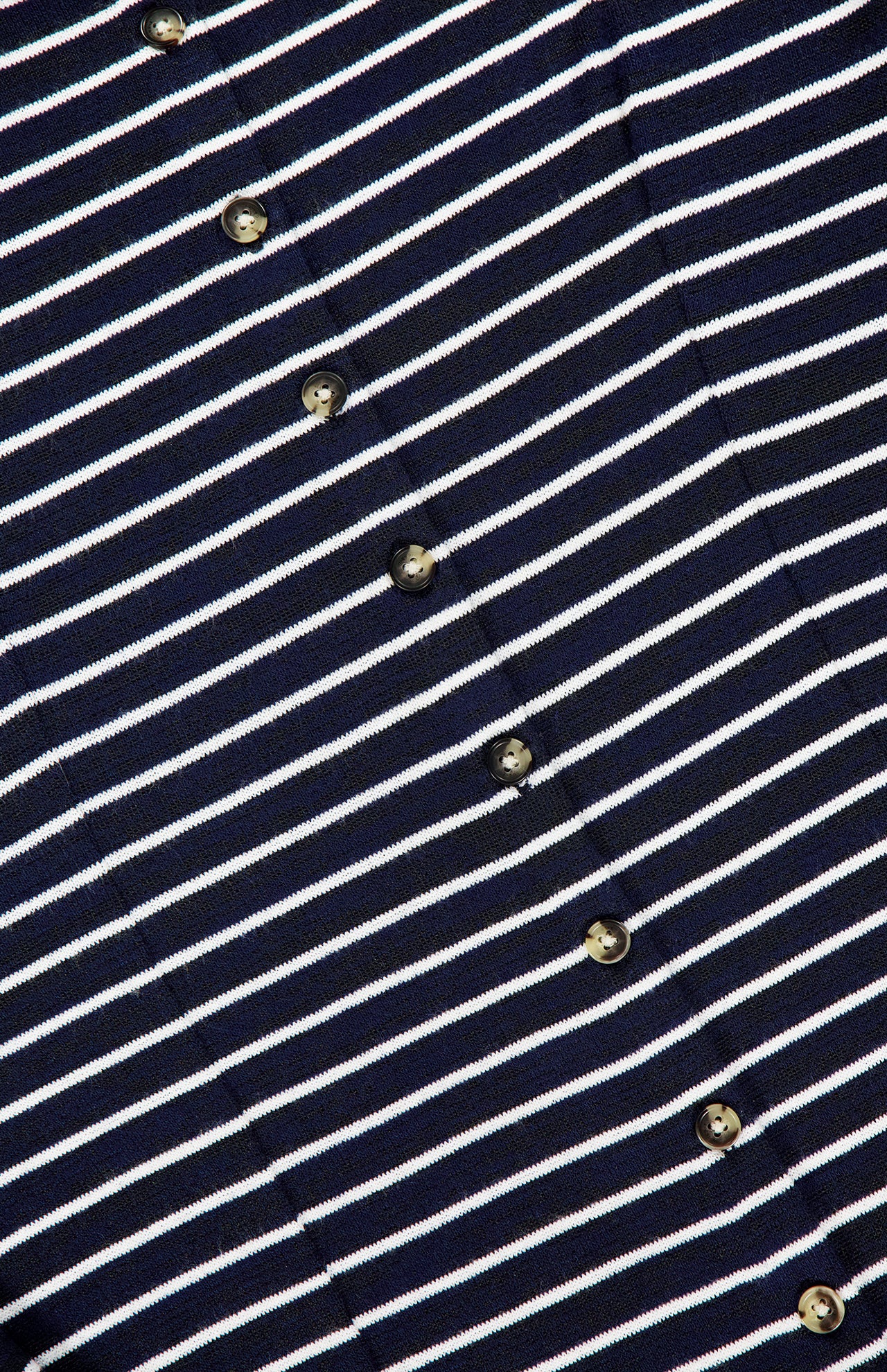 Close-up of the RAG & BONE Knit Button Tie Stripe Dress, showcasing navy blue fabric with white horizontal stripes and a diagonal row of small round buttons.
