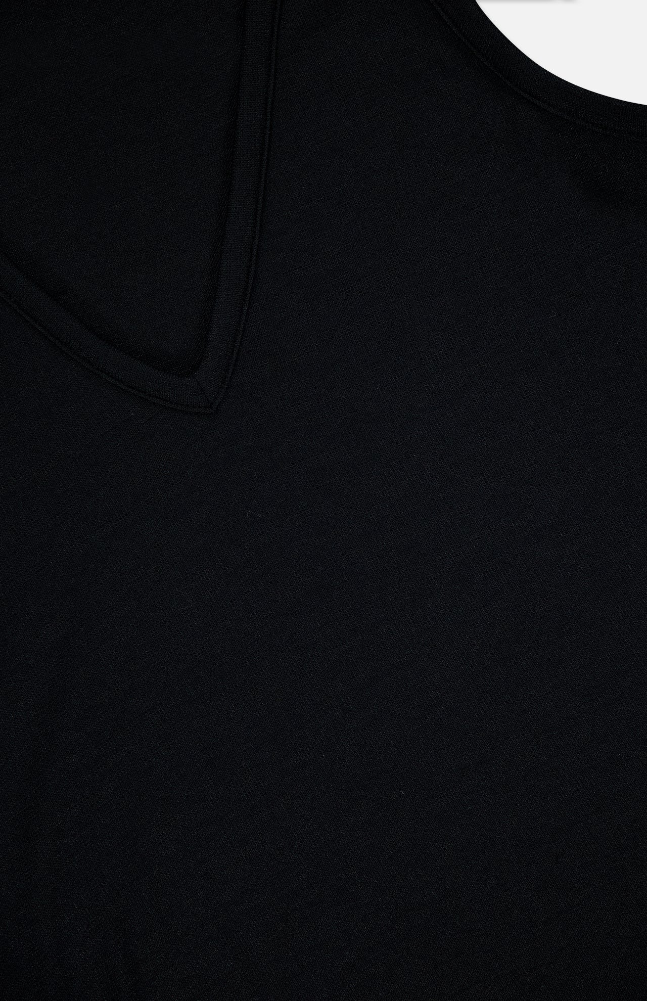 Close-up of The Knit V-Neck Tank Top by RAG & BONE, highlighting the textured black fabric and upper-left section of the V-shaped neckline.