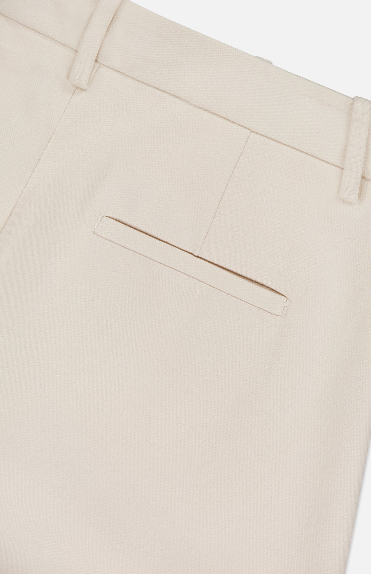 Close-up of the back pocket area of the RAG & BONE Vicky Barrel Leg Ponte Pant in off-white, featuring a single welt pocket and belt loops, shown against a plain white background.