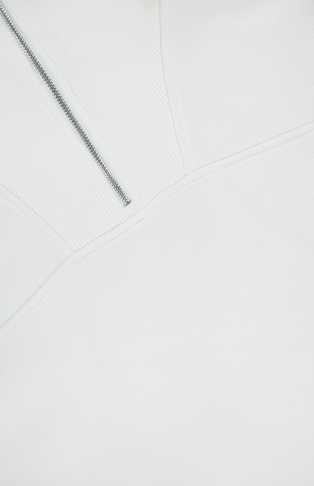 Close-up of the RAG & BONE Vintage Terry Half Zip Muscle Tank Top in white, highlighting textured athleisure fabric, diagonal seam, visible metal zipper, and detailed stitching.