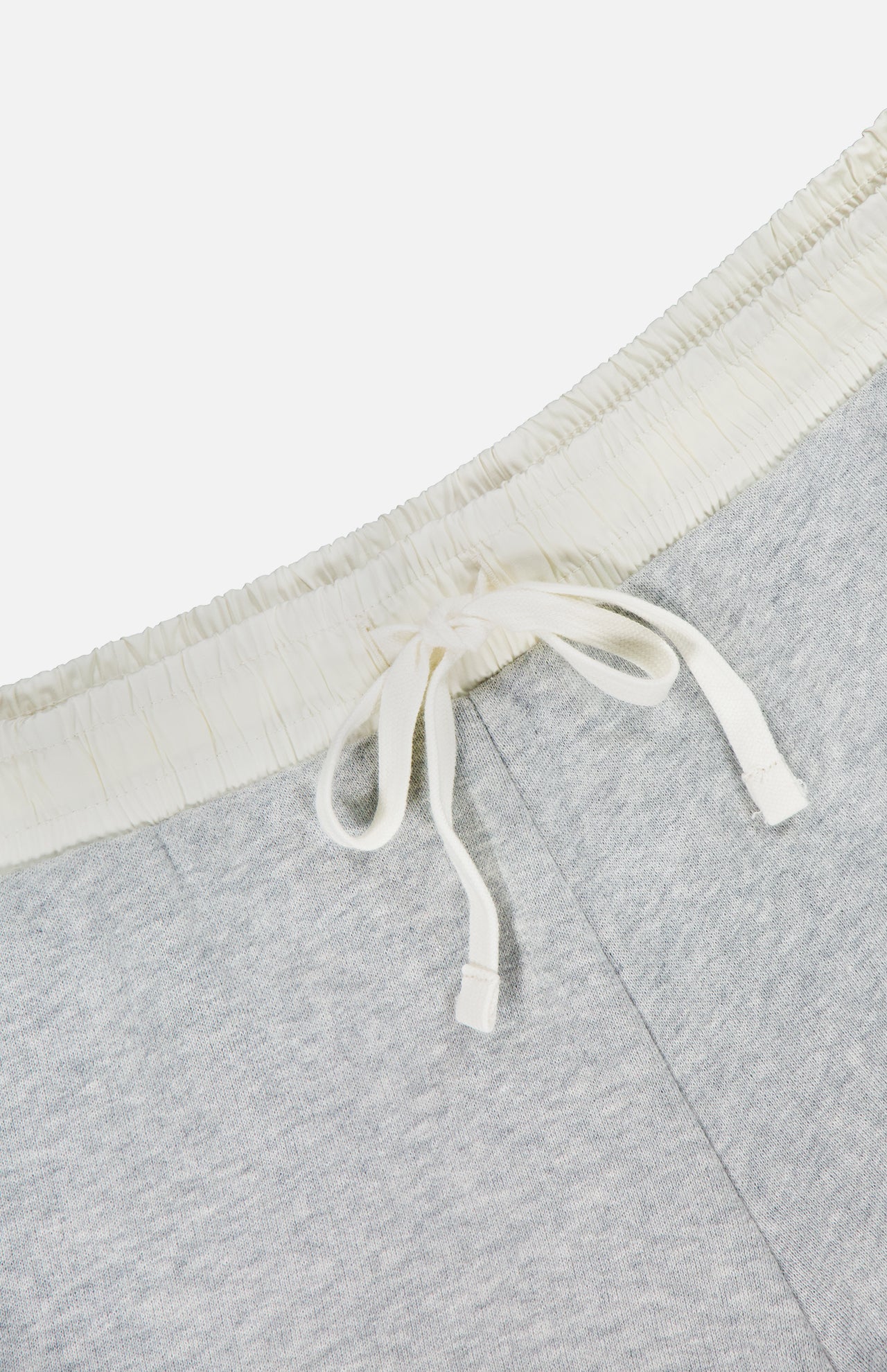 Close-up of the RAG & BONE Vintage Terry Mix Media Sweatshort in light gray, featuring an off-white elastic waistband and white drawstring, showcasing its textured cotton-blend fabric—perfect for casual wear or travel.