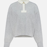 The Vintage Terry Oversized Polo Sweatshirt by RAG & BONE is a light gray cotton-blend terry top with an off-white collar, short button placket, relaxed fit, cuffed sleeves, and a slightly curved hem.