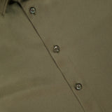 Close-up of the Adrien Satin Long Sleeve Button Front Shirt by RALPH LAUREN COLLECTION, in olive green. Features a pointed collar, four visible buttons, and a silky smooth, slightly shiny fabric for a luxurious look.
