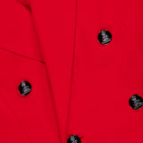 Close-up of the Camden Cashmere Jacket by RALPH LAUREN COLLECTION, a vivid red double-breasted blazer with six black buttons featuring silver accents. Overlapping lapels and structured fabric stand out in this elegant design.