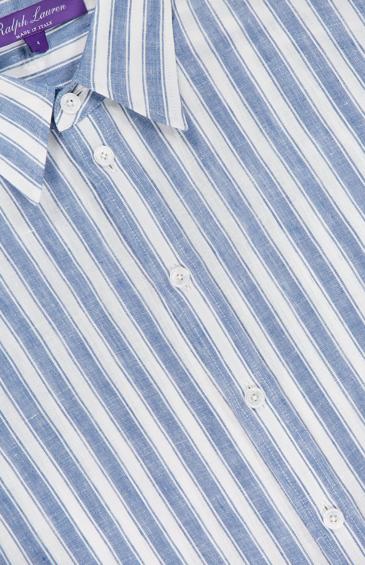 Close-up of the Carol Short Sleeve Day Dress by RALPH LAUREN COLLECTION, featuring blue and white vertical stripes, white buttons, a pointed collar, and a label highlighting its Italian craftsmanship.