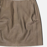 The Carreen Leather Mini Pencil Skirt from RALPH LAUREN COLLECTION, crafted in bronze leather with simple stitching and subtle pocket details, is displayed on a white background.