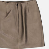 The Carreen Leather Mini Pencil Skirt by RALPH LAUREN COLLECTION is a bronze-hued mini skirt featuring a front seam and subtle pleats near the waistband, crafted from soft faux leather and displayed laid flat on a white background.