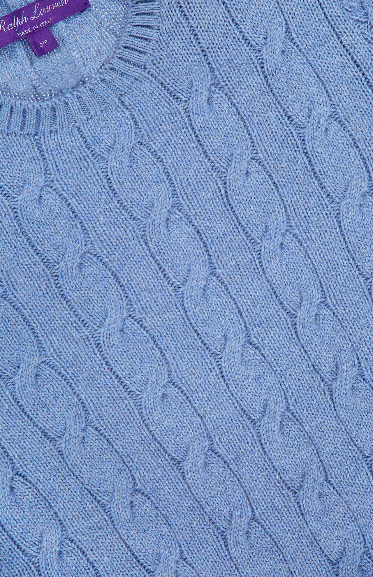 Close-up of the light blue Cashmere Classic Cropped Pullover Sweater by RALPH LAUREN COLLECTION, showcasing a purple label at the neckline for a signature, timeless look.