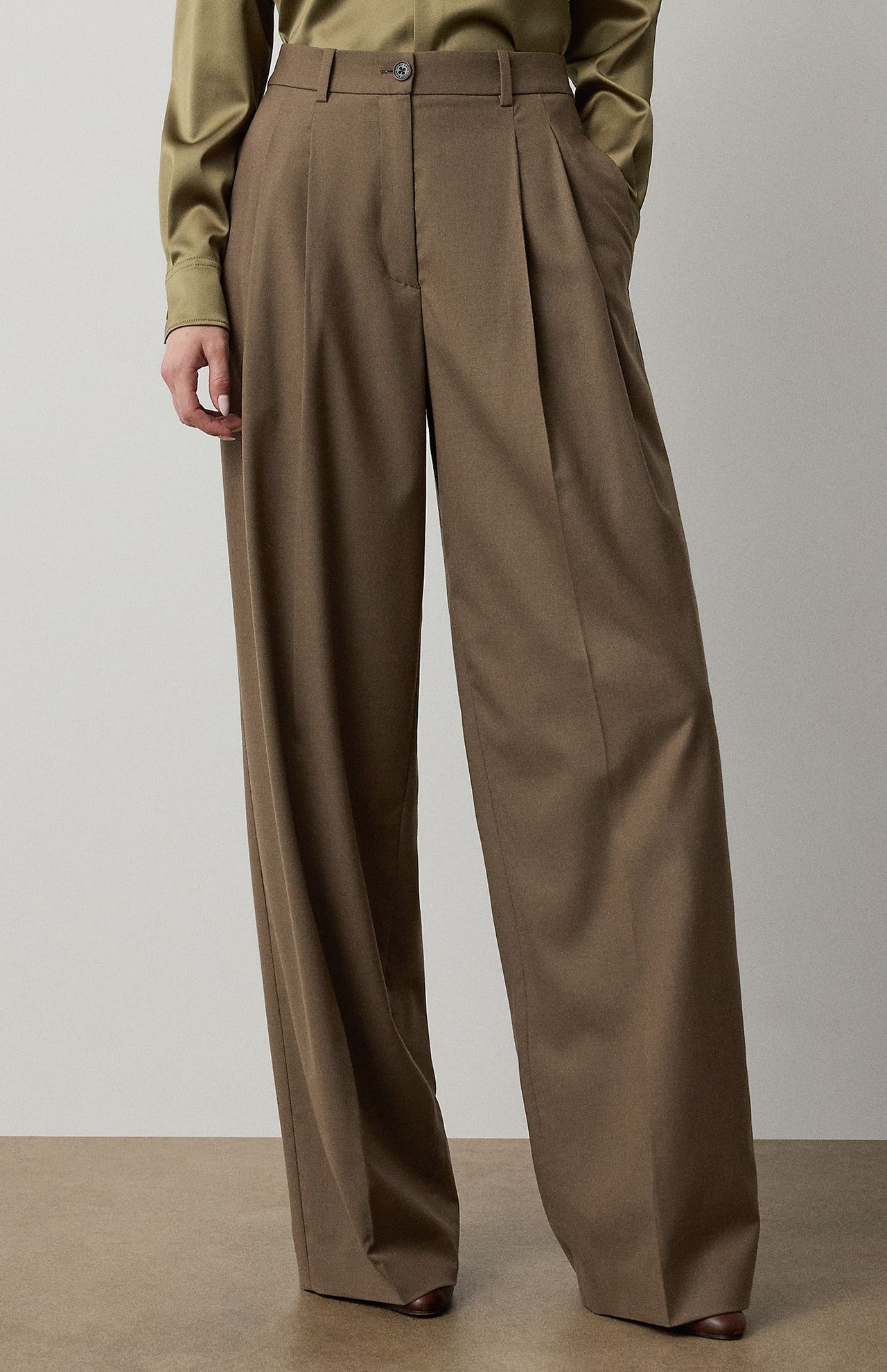 RALPH LAUREN COLLECTION Fine Wool Standard Pants in brown, featuring a high-waisted, relaxed fit with a single front pleat, worn with a muted green button-down shirt.
