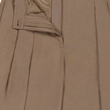 The image features the upper section of the Fine Wool Standard Pants by RALPH LAUREN COLLECTION—relaxed fit brown trousers crafted from stretch wool, shown with the zipper and button undone to reveal a glimpse of the inner lining and waistband.