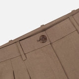 Close-up of the Fine Wool Standard Pants by RALPH LAUREN COLLECTION, crafted from stretch-wool fabric in brown, highlighting the waistband, belt loops, button closure, and a portion of the zipper fly against a white background.