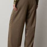 Back view of RALPH LAUREN COLLECTION Fine Wool Standard Pants in olive-brown, featuring a relaxed fit, stretch-wool fabric, a high waist, belt loops, and buttoned back pockets.