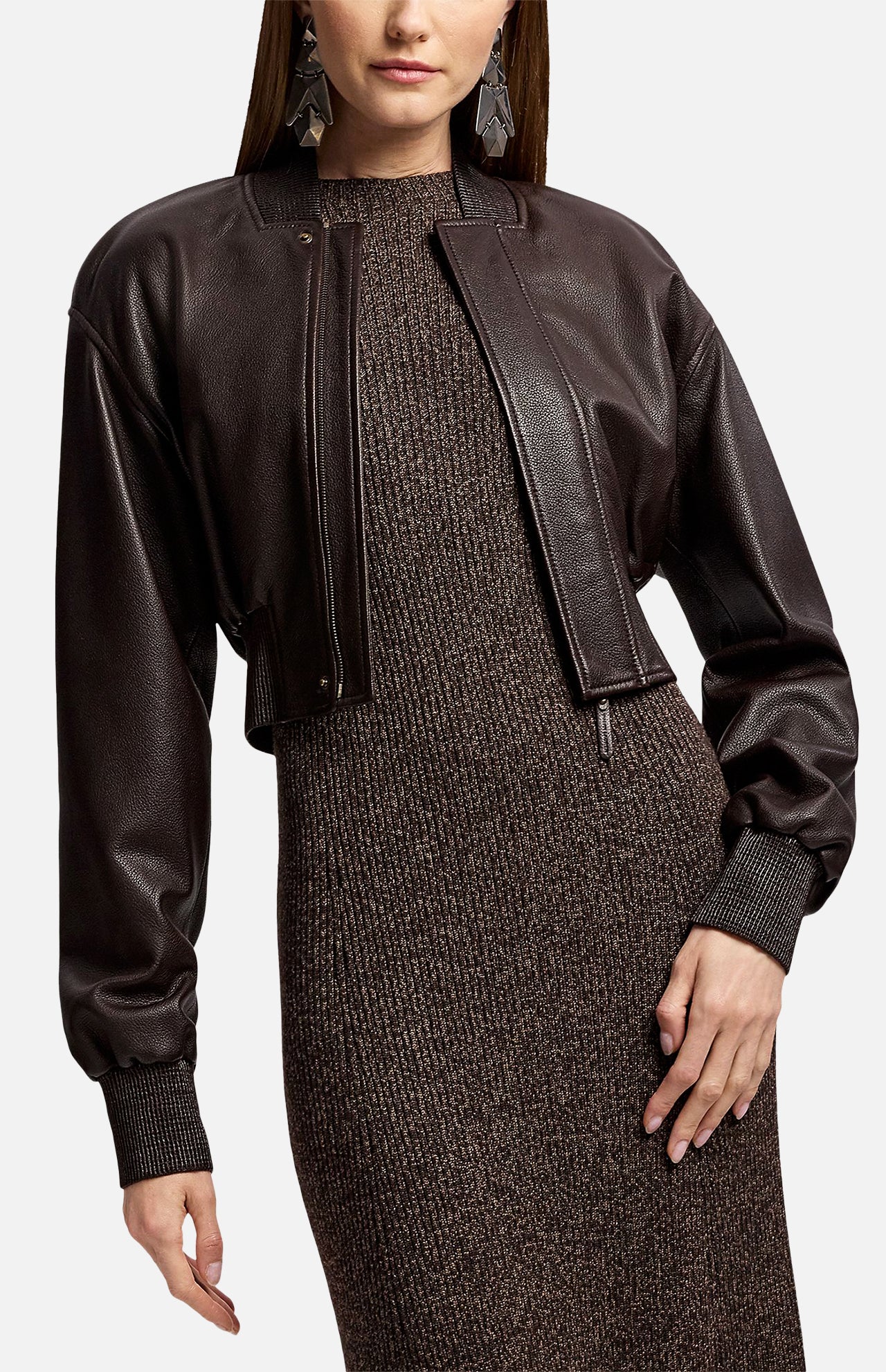 A person wearing a cropped dark brown Ralph Lauren Collection Grained Leather Bomber Jacket over a fitted, textured dark knit dress.